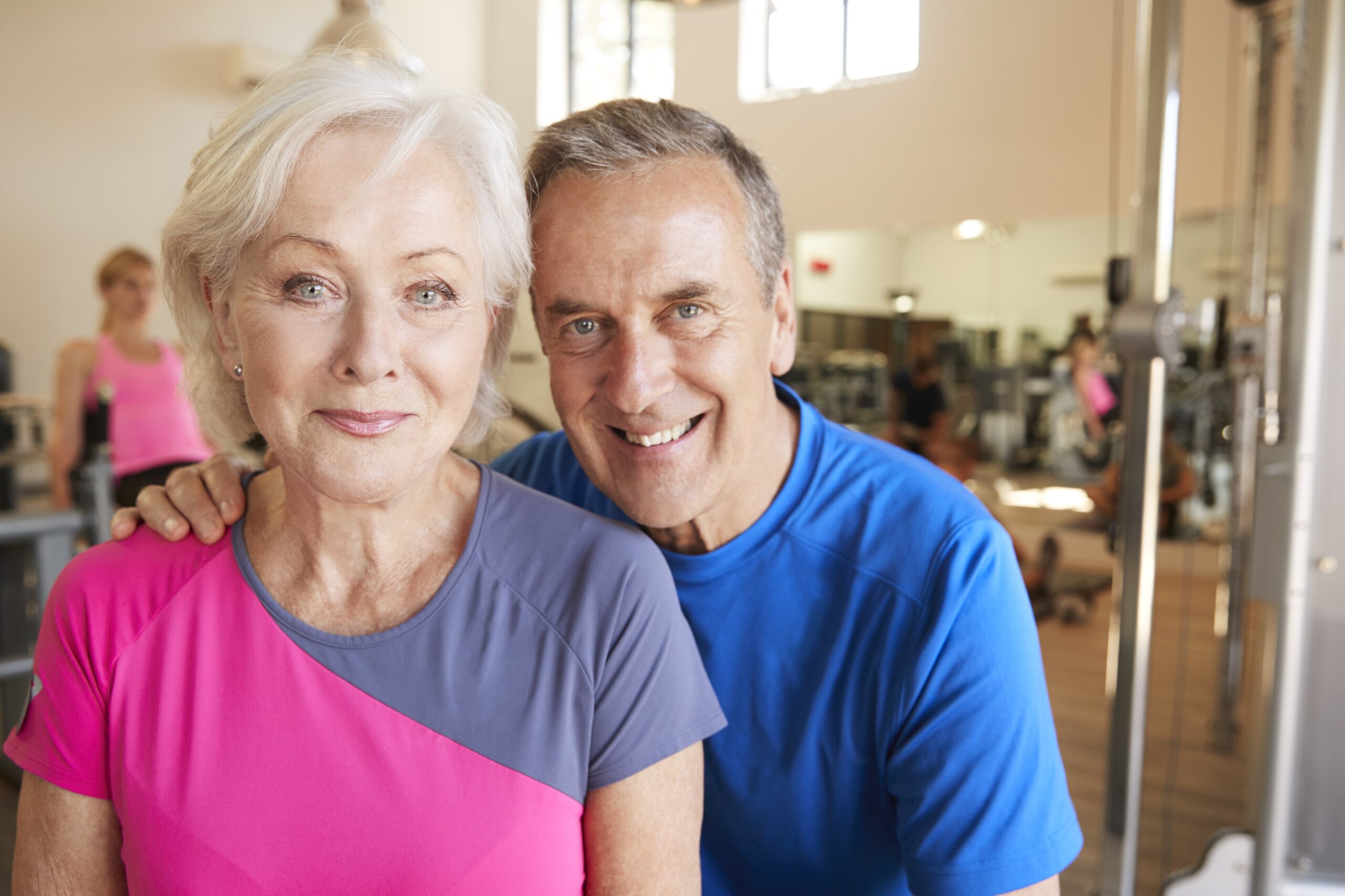 Portrait Of Active Senior Couple Exercising In Gym Together